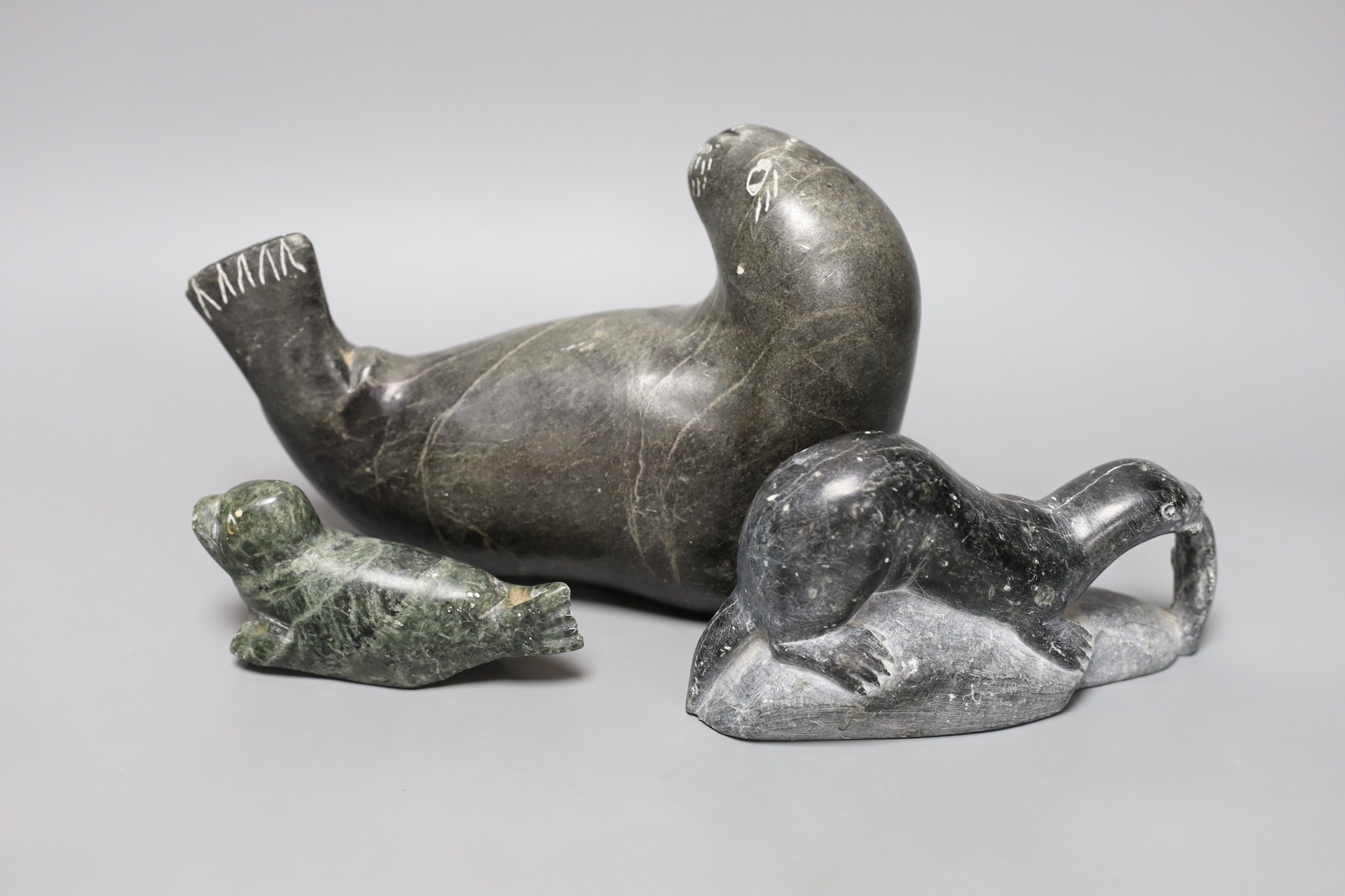 Three Inuit stone carvings, two seals and an otter. Largest 20cm long